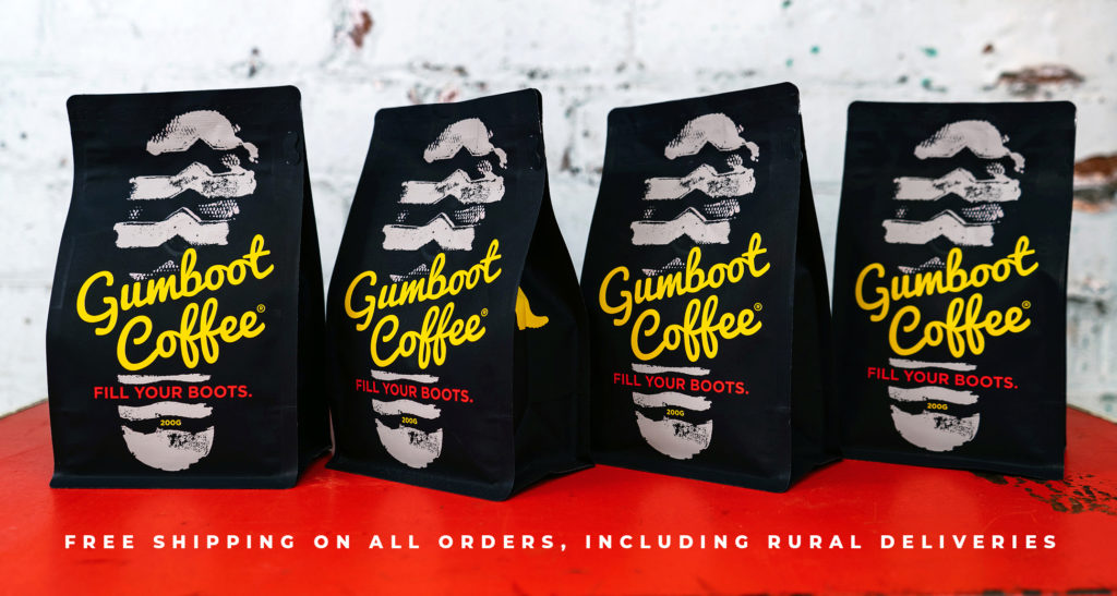 Bags of Gumboot Coffee lined up on an red table. Subtitle says "Free shipping on all orders, including rural deliveries".